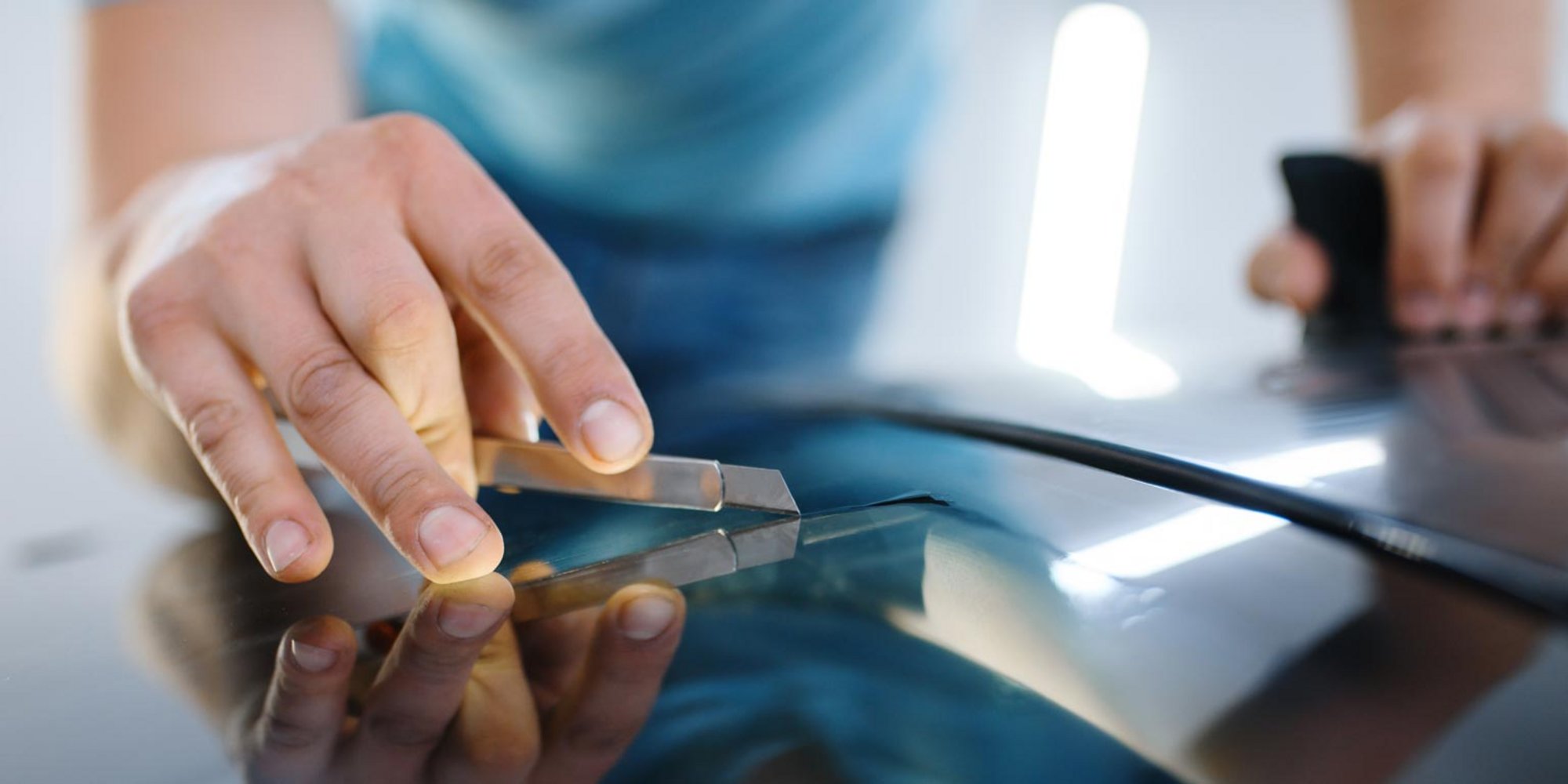 Werkzeug wird an Windschutzscheibe angesetzt.